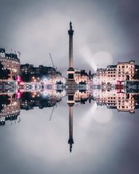 Digital composite image of illuminated buildings and city against sky