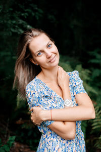 Portrait of young woman standing in forest