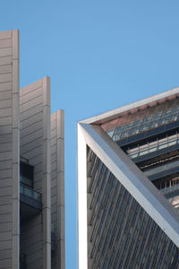 Low angle view of office building against clear blue sky