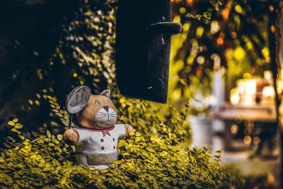 Close-up of toy statue by plants