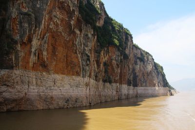 Rock formations by sea against sky