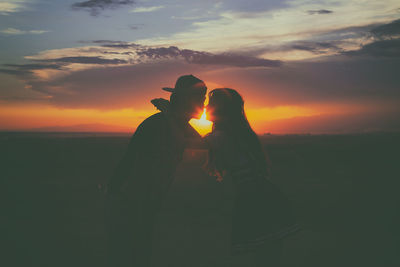 Silhouette couple against romantic sky during sunset