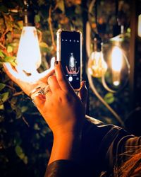 Midsection of man using mobile phone at night