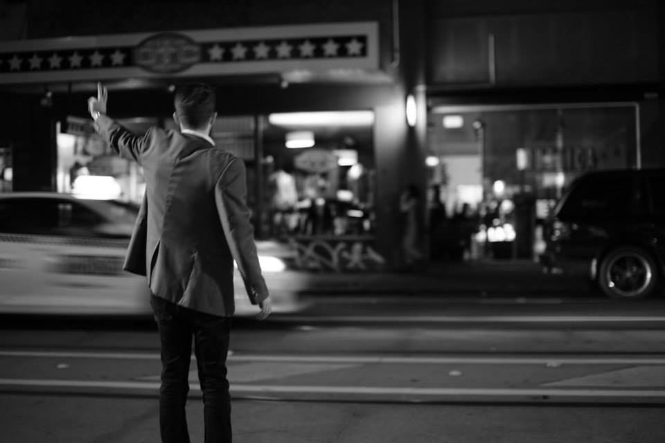 REAR VIEW OF MAN STANDING ON STREET