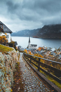 High angle view of hallstat village with buildings against moody sky