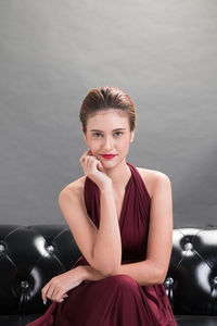 Portrait of young woman sitting on sofa