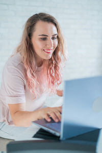 Portrait of young woman using laptop at home