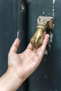 Cropped hand touching doorknob