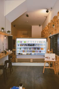 Juice bottles in illuminated refrigerator in cafe