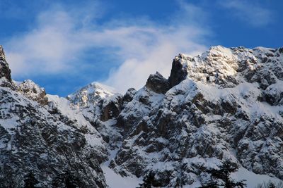 Low angle view of snowcapped mountains against sky