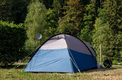 Tent on field against trees in forest