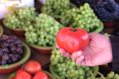 Close-up of hand holding strawberries at market stall