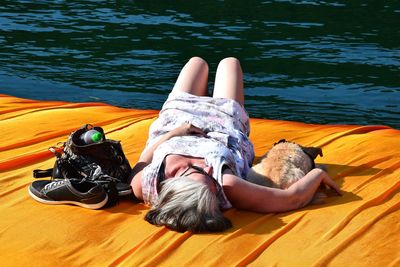 Woman with dog relaxing on pier