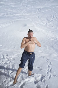 Adult man practicing cryotherapy, in the snow. cryotherapy 