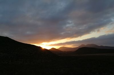 Scenic view of silhouette mountains against sky during sunset