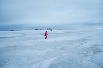 Man in sea against sky during winter