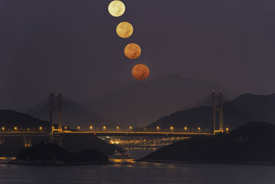 Illuminated bridge over river at night