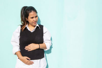 Full length of woman standing against wall