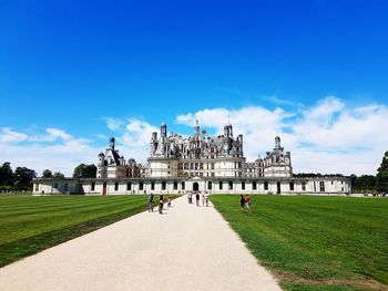 View of historical chateau building in city against blue sky