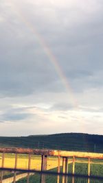 Rainbow over landscape against sky