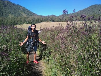 Full length of woman standing on field against sky