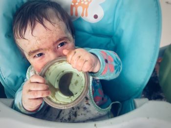 Close-up of messy baby with empty bowl