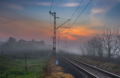 Railroad tracks against sky during sunset