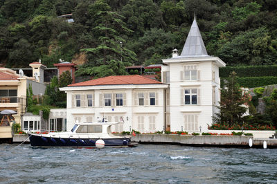 Building by sea against trees