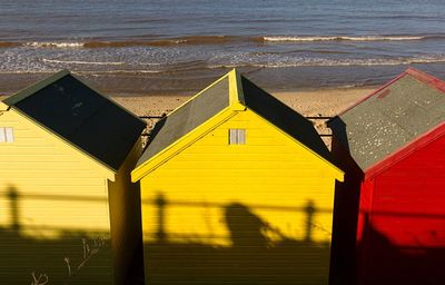 Yellow umbrella by sea against sky