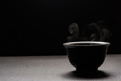 Close-up of coffee cup against black background