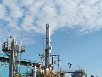 Low angle view of industry against blue sky