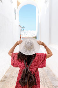 Rear view of woman standing against wall