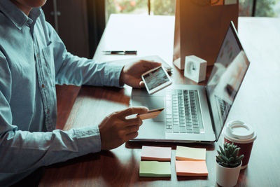 Midsection of man using laptop