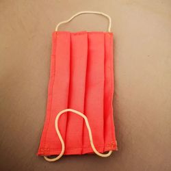Close-up of red ball hanging on table against wall