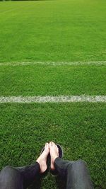 Low section of woman relaxing in soccer field