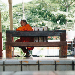 Rear view of man sitting on bench in park