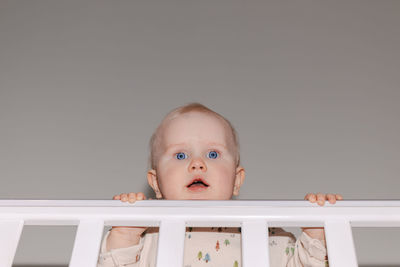 Close-up of a cute baby standing in his cot