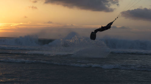 Man splashing water in sea against sky