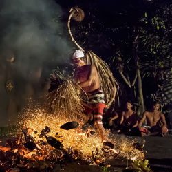 Midsection of woman with illuminated water at night