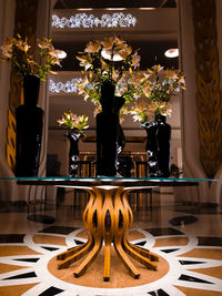 Illuminated flower vase on table at home