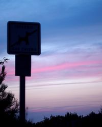 Low angle view of road sign against sky