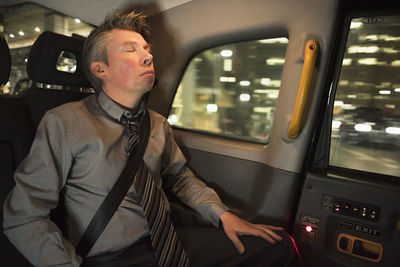 Man sitting with eyes closed in car