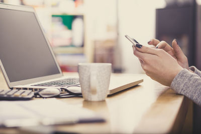 Midsection of man using laptop on table