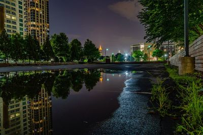 Reflection of building in puddle at night