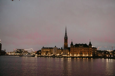 Illuminated buildings in city at dusk