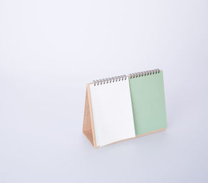 High angle view of blank desk calendar against white background