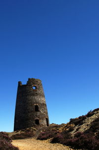 Low angle view of lighthouse against clear blue sky