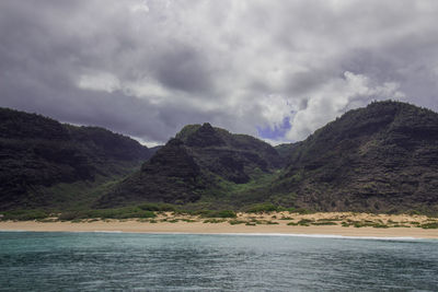 Scenic view of sea and mountains against sky