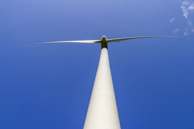 Low angle view of wind turbine against clear blue sky