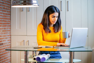 Businesswoman using laptop on desk in office